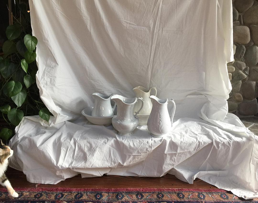 Enter stage right...an admirer checks out our collection of vintage and antique white ironstone china pitchers and basins headed Spotwards this holiday weekend.